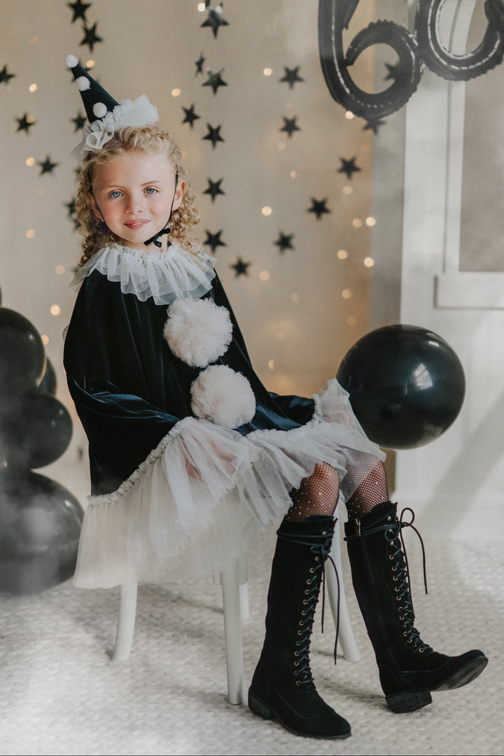 Girl wearing pirouette clown costume with black balloon at Halloween party