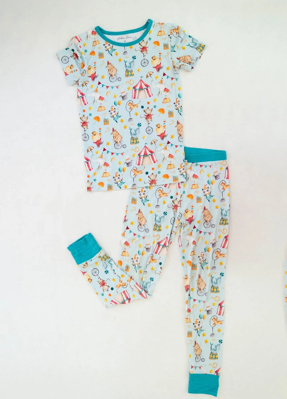 Flat lay of Take Me to the Circus bamboo kids two-piece pajamas with short sleeve top and matching long pants.