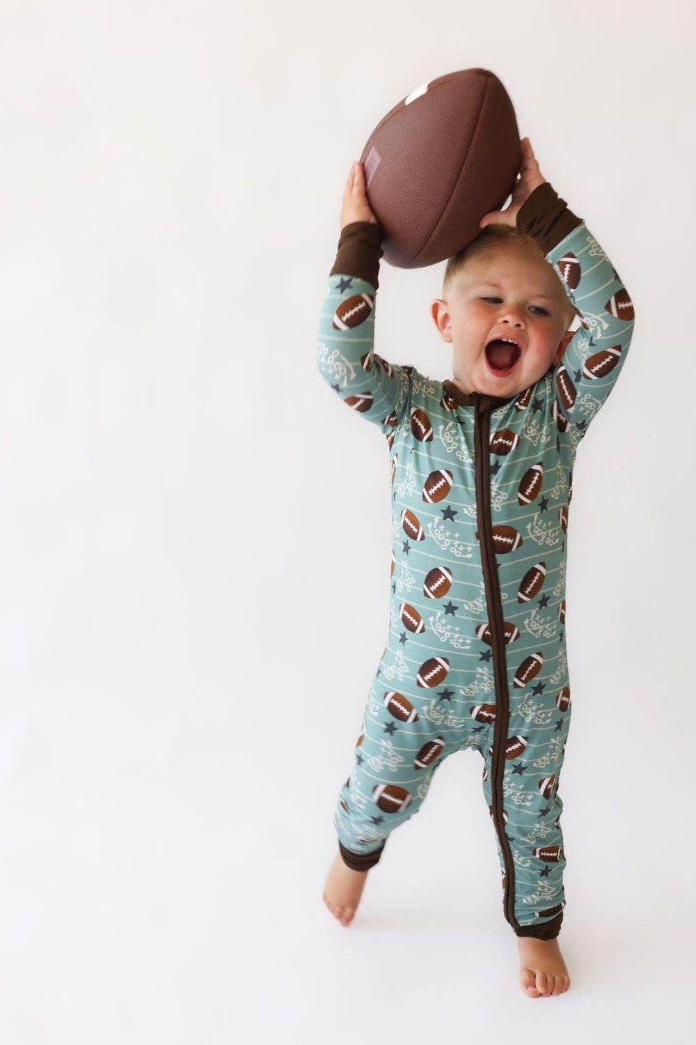 Close-up of football print and dual zipper design on Football Fans romper