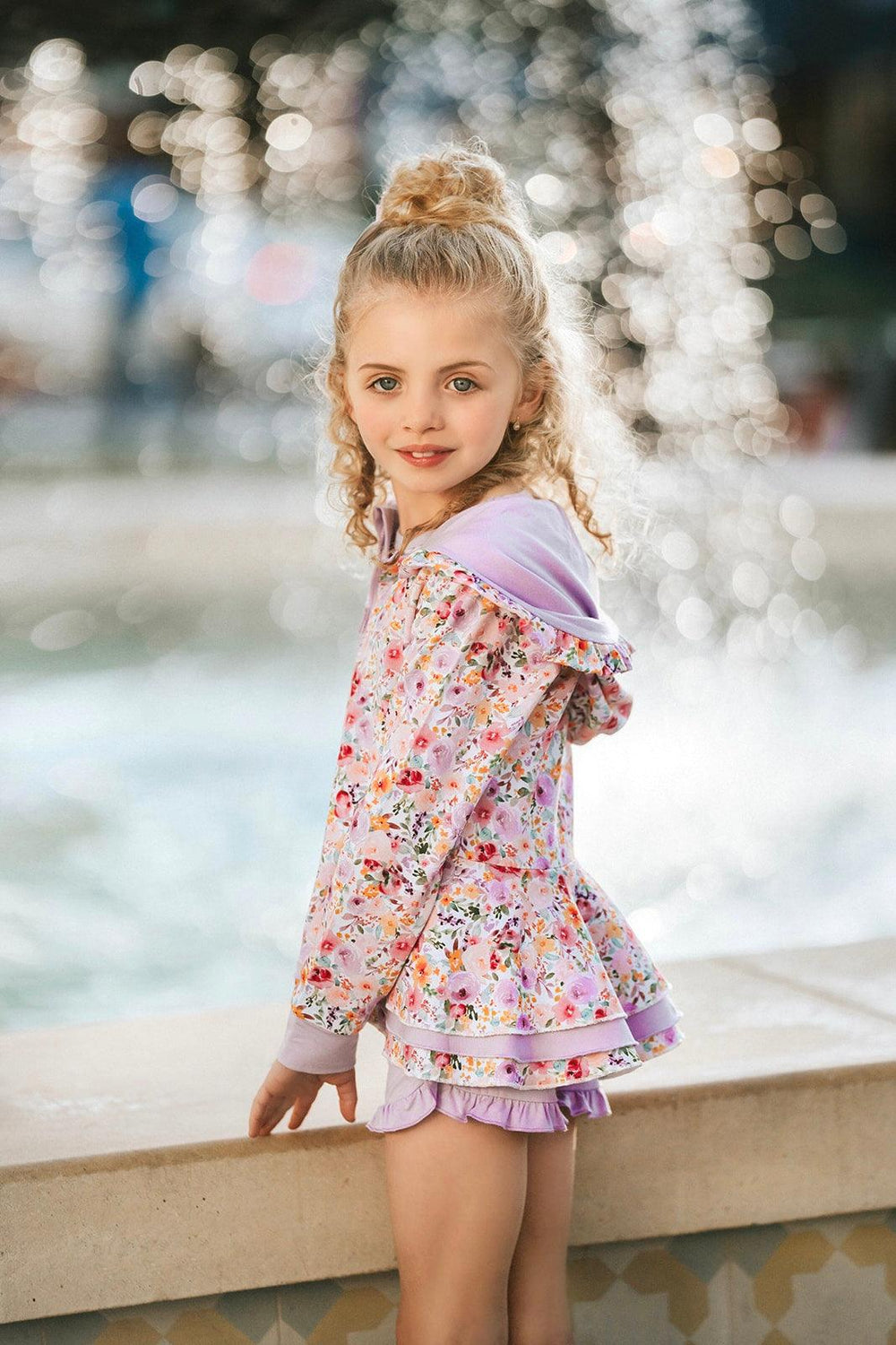 Close-up side angle showing ruffle detail on flower garden girls jacket with peplum silhouette and soft floral print.