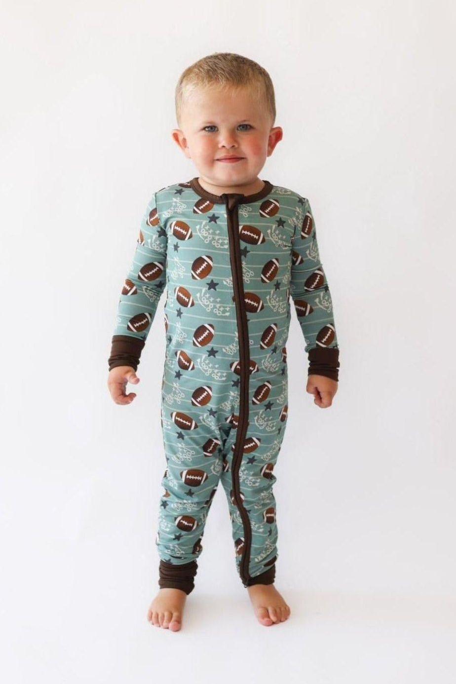 Toddler wearing Football Fans bamboo zipper pajamas with fold-over cuffs