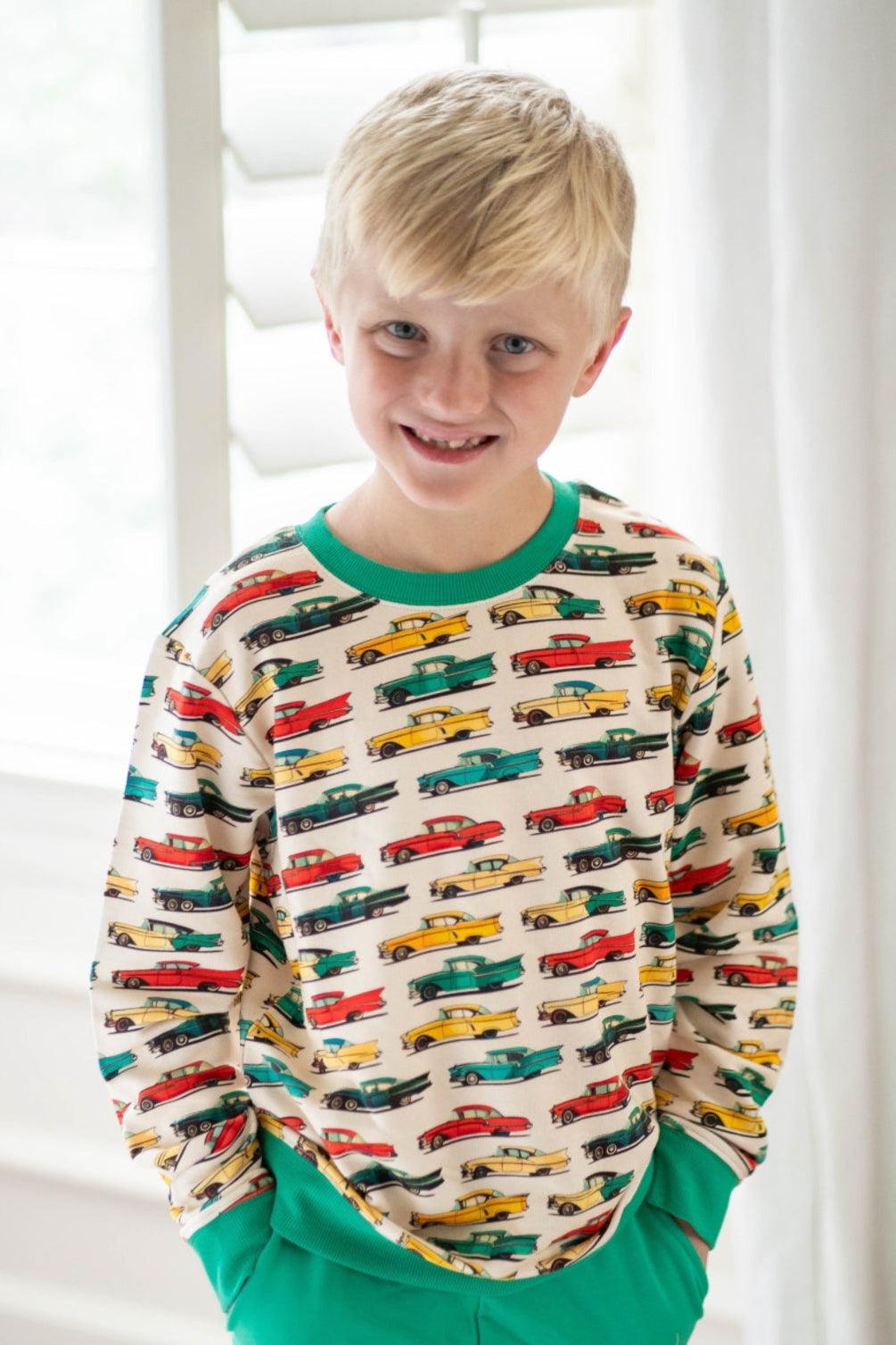 Little boy wearing classic cars French terry sweatshirt, smiling and front-facing in natural lighting — comfy and playful outfit.