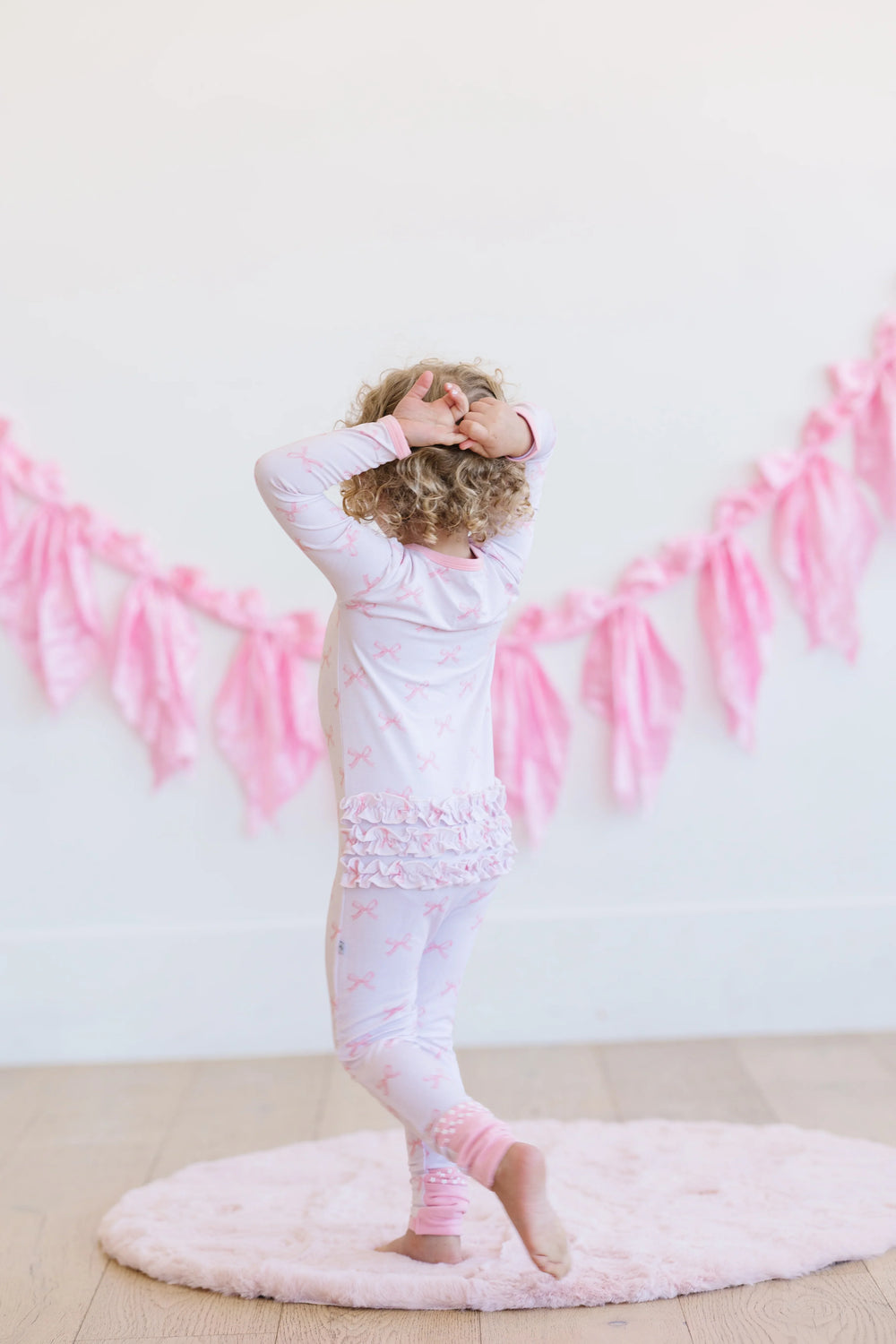 Back view of pink bows long sleeve bamboo zipper pajamas for baby or toddler, showing full footie coverage.