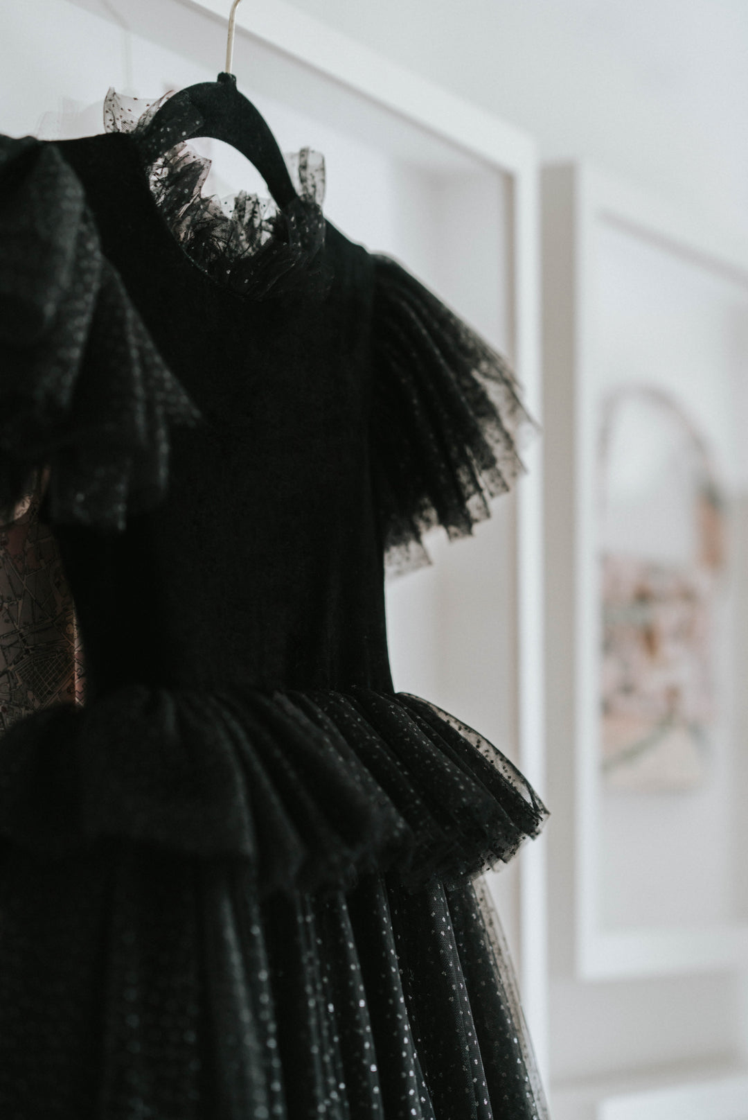 Heirloom quality witch dress hanging on wall, black velvet design