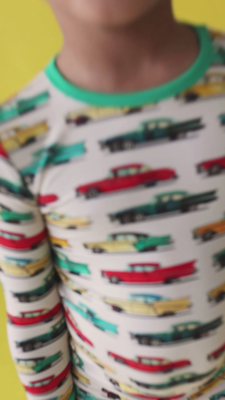 Video of toddler boy wearing classic cars bamboo two-piece pajama set, playing and moving comfortably in lightweight, buttery soft pajamas with vintage car print.