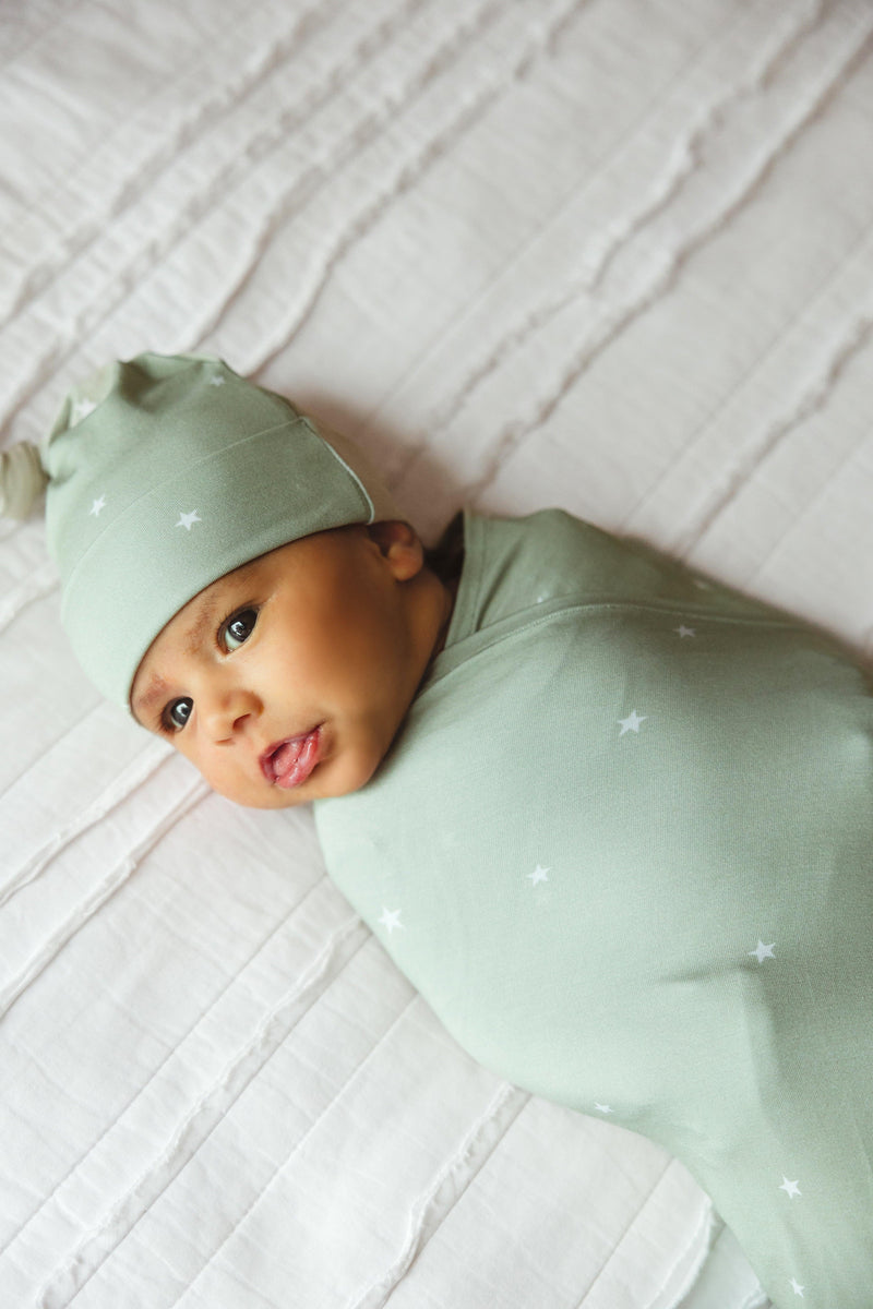 Newborn baby wrapped in sage stars bamboo swaddle blanket, showing cozy, secure fit and soft stretch — ideal for gifting, hospital take-home outfits, or sleep.
