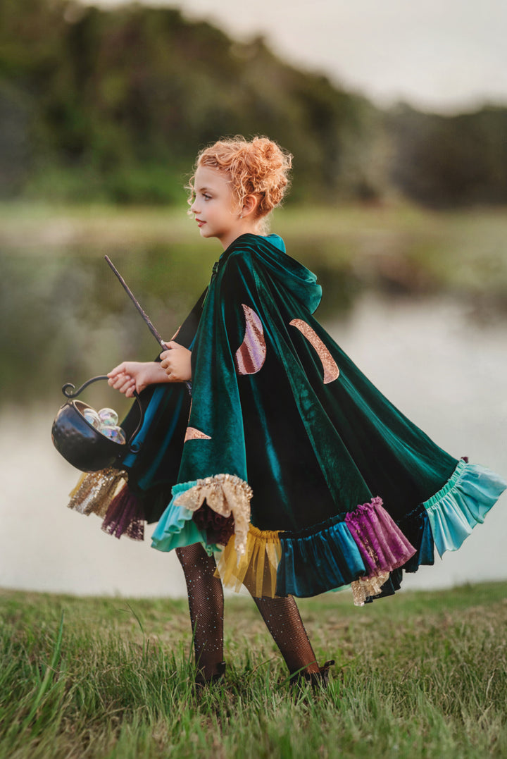 Child in matching green Hocus Pocus inspired witch costume capes. sanderson sisters halloween costumes.