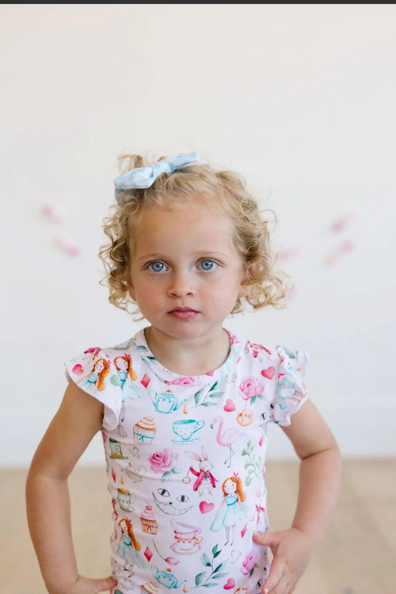 Toddler girl sitting in bamboo ruffle sleeve bodysuit with snap bottom, soft stretch fabric for comfort and mobility.