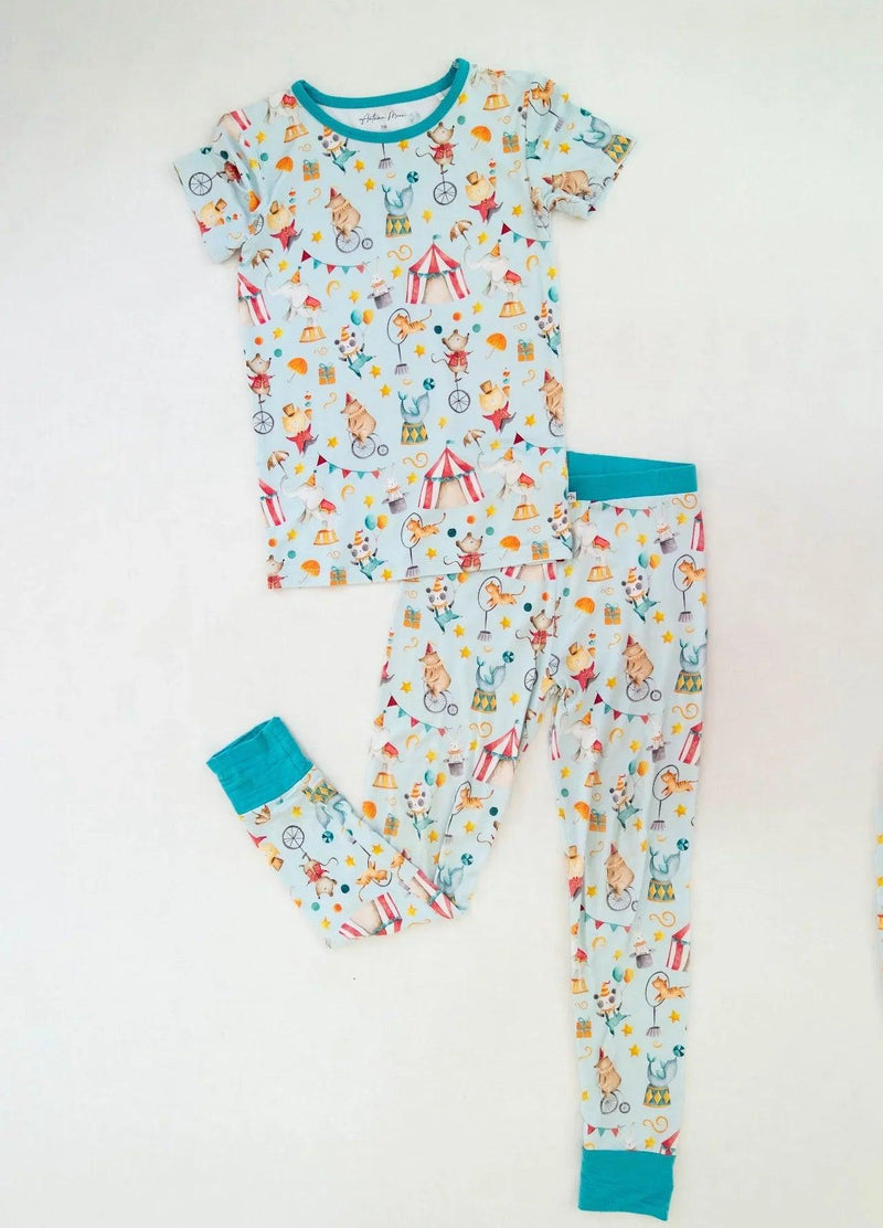 Flat lay of Take Me to the Circus bamboo kids two-piece pajamas with short sleeve top and matching long pants.