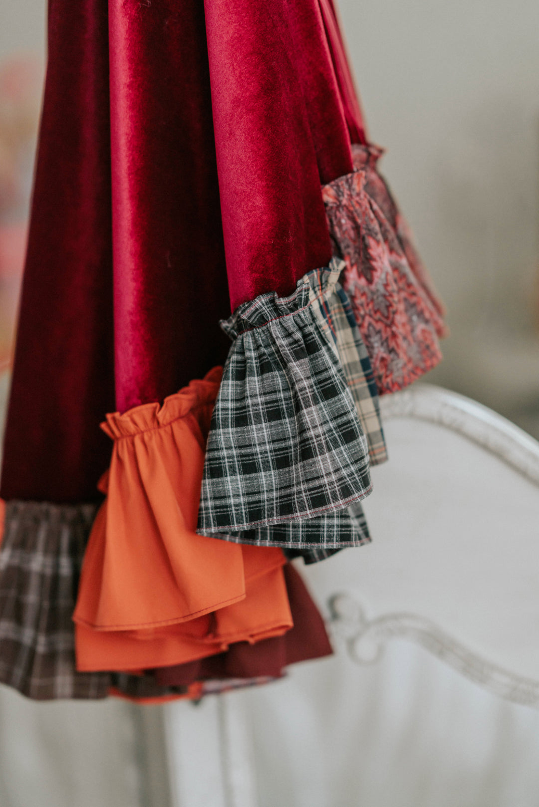 Close-up of red velvet Mary Sanderson witch cape with orange ruffle trim