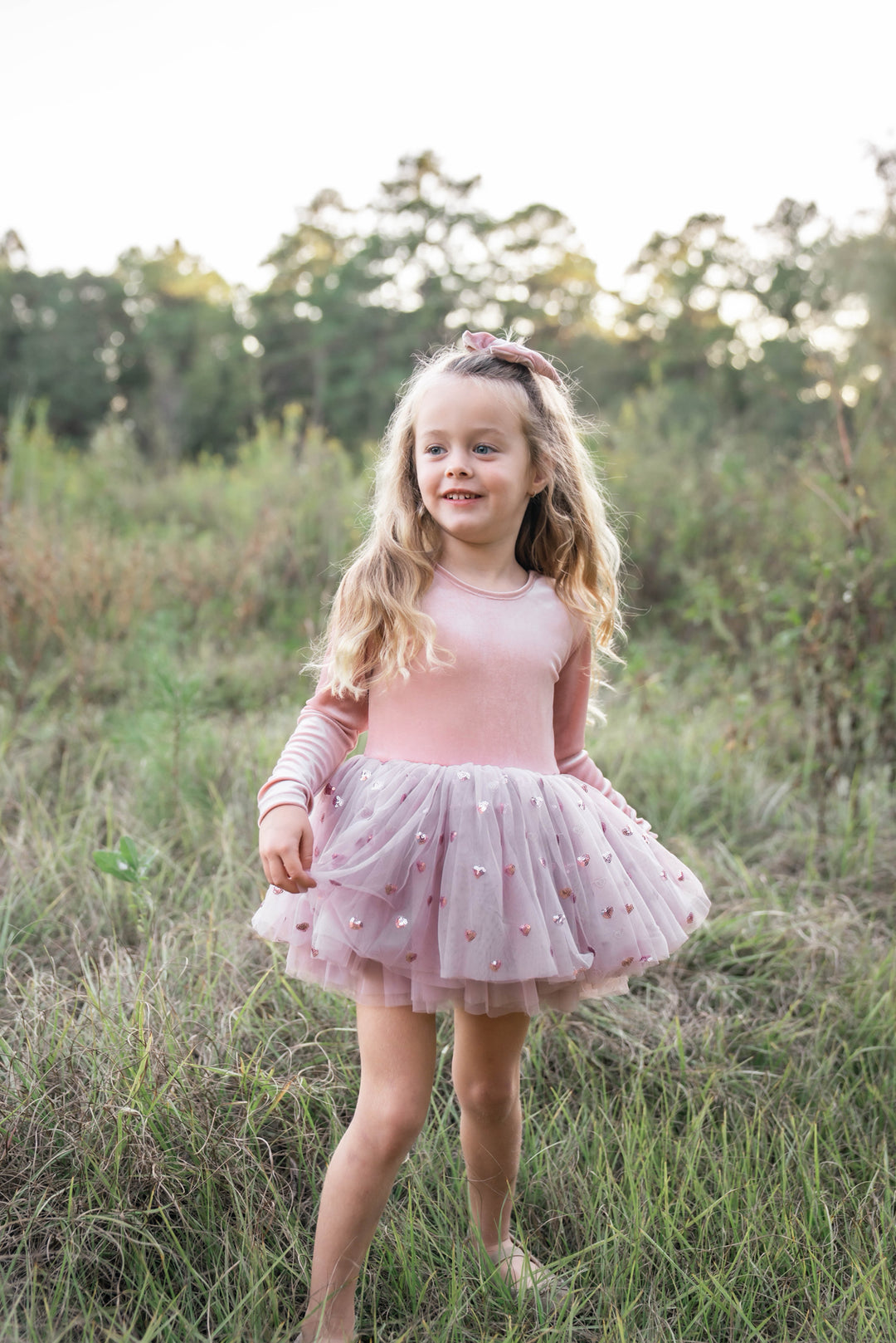 Girl posing outdoors in rosewood velvet tutu dress with whimsical heart tulle skirt.