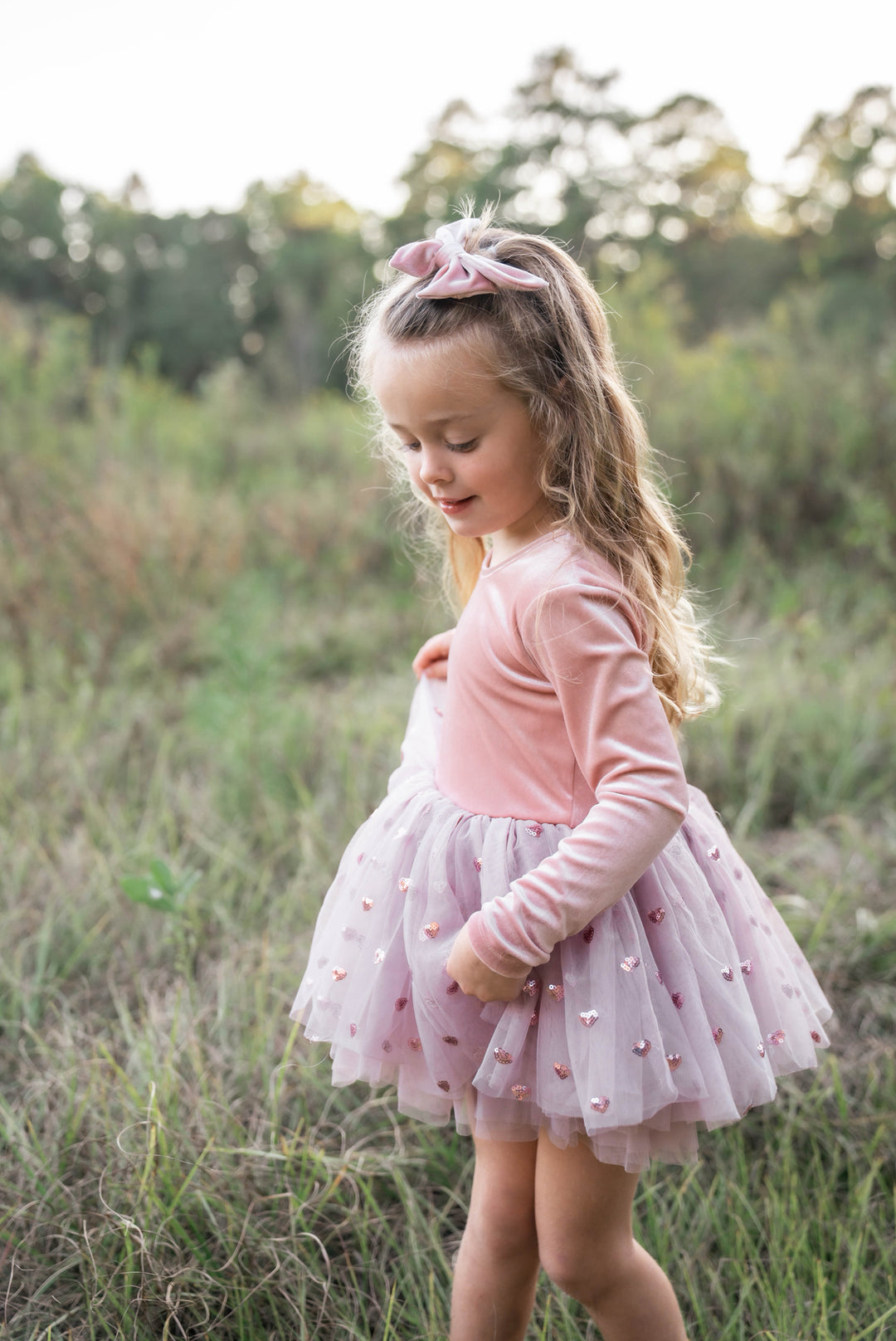 Girl smiling and playing outdoors in rosewood velvet tutu dress.