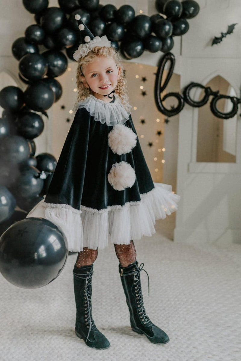 Black velvet pirouette clown cape with ivory tulle ruffle trim hanging on vintage wardrobe