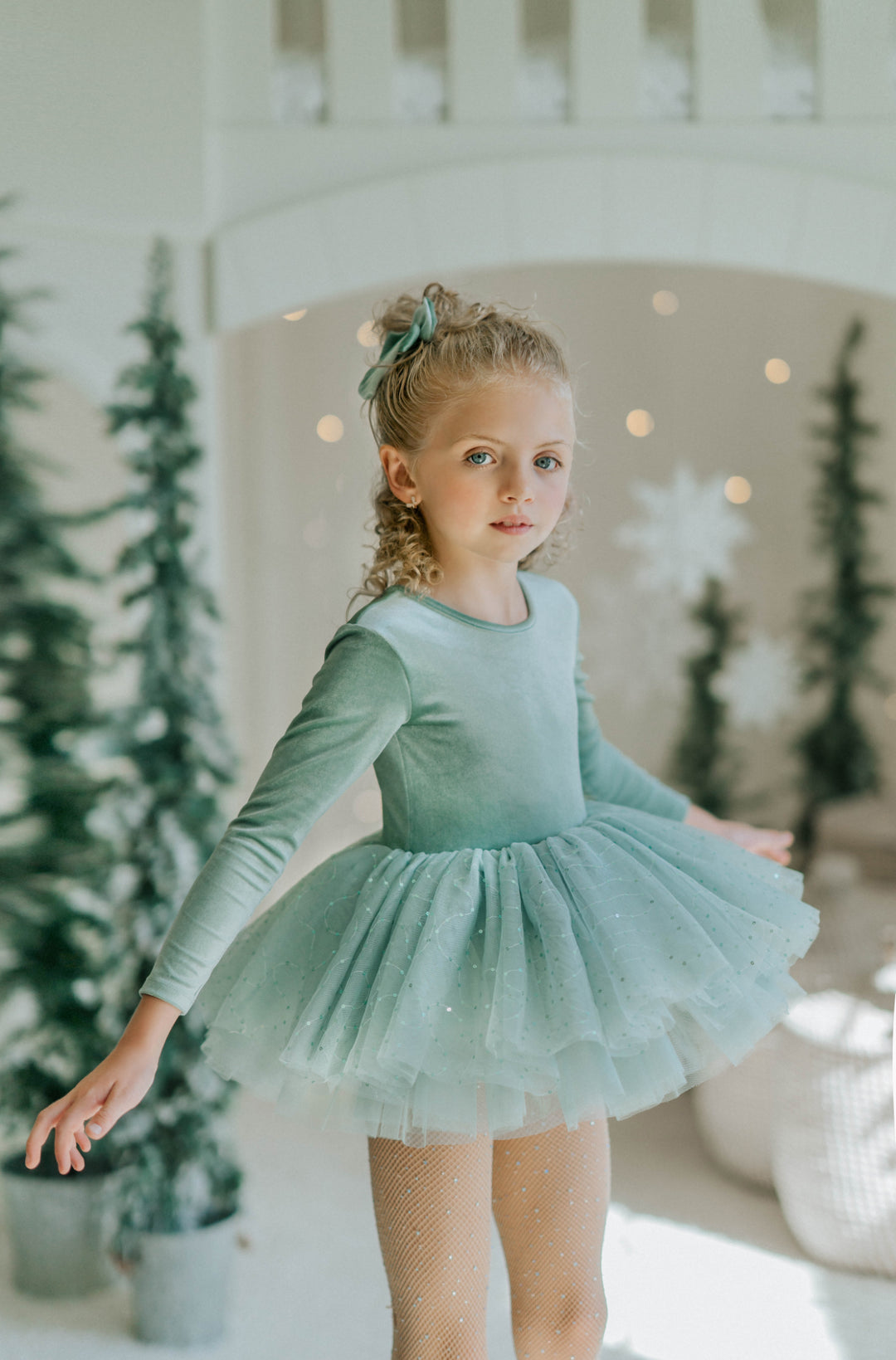 Girl twirling in Willow green tutu dress showing full volume and playful movement.
