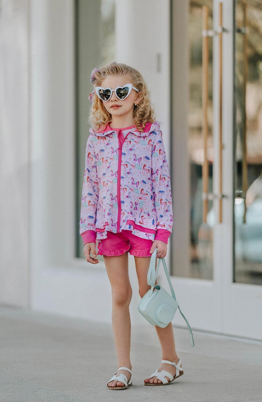 Girl wearing Magical Unicorns zipper jacket, front-facing to show full zipper closure, peplum hem, and long sleeves — cozy, stylish, and great for school, play, or travel.
