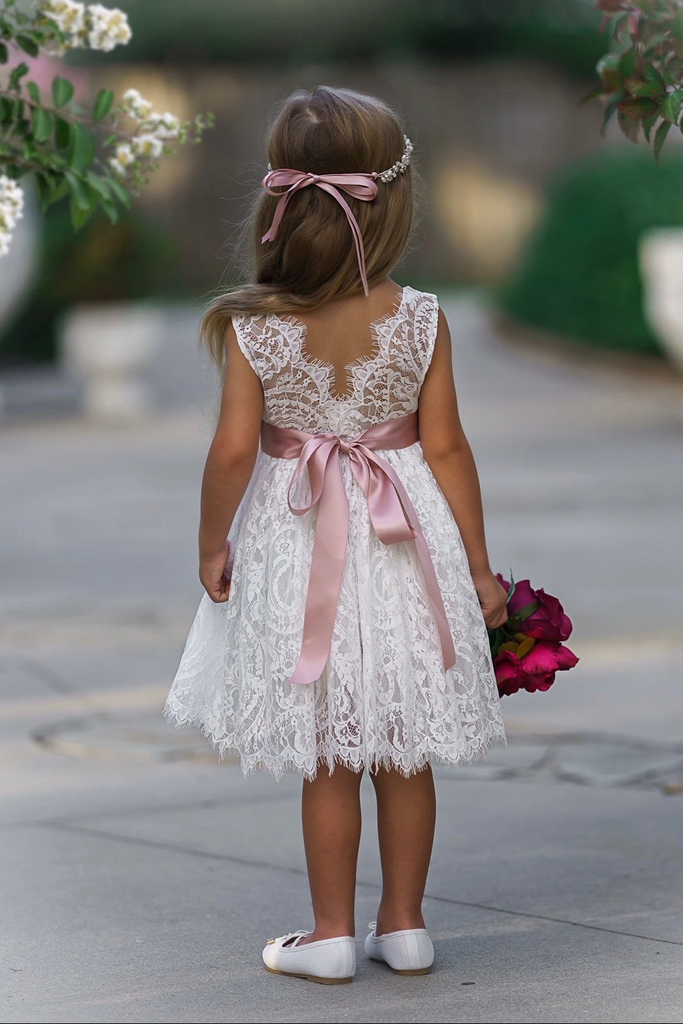 Soft white lace dress back view with V-shaped eyelash lace and satin bow detail
