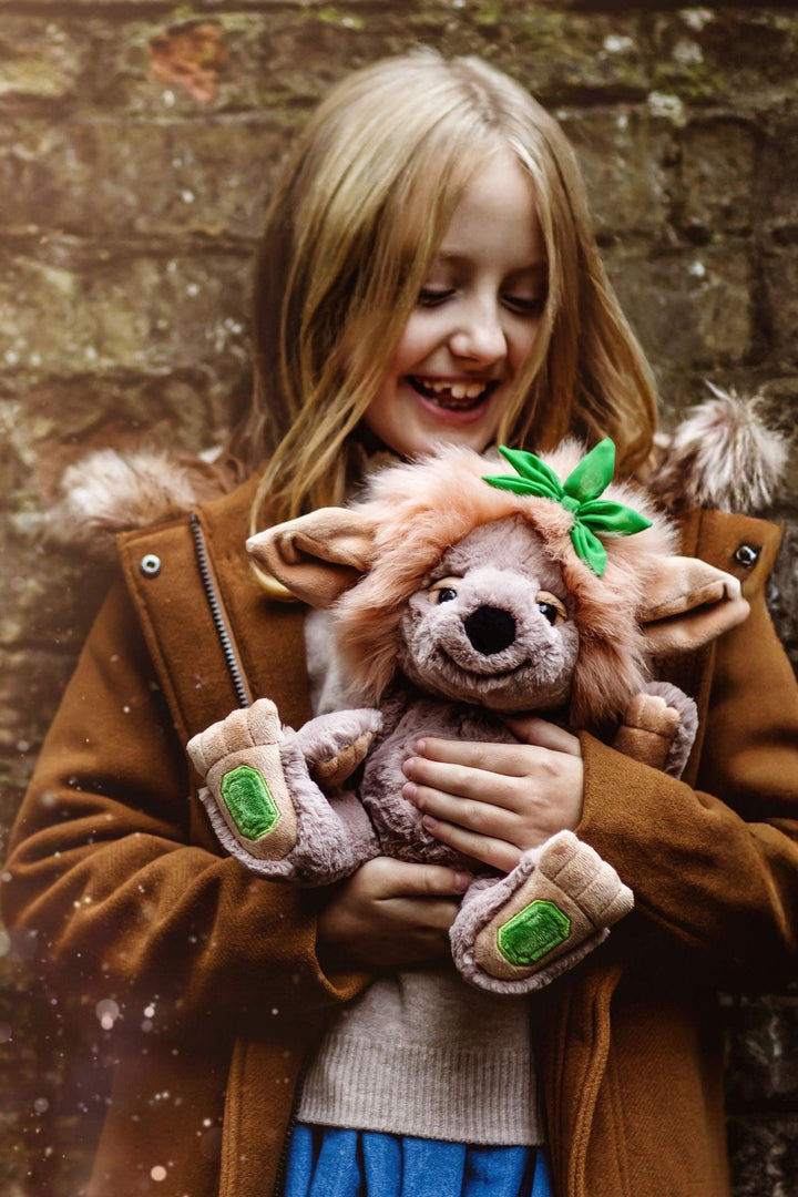 Emerald Lou Crystal Troll by Charlie Bears held by a child in a woodland setting with honey-toned mane and green gemstone paws