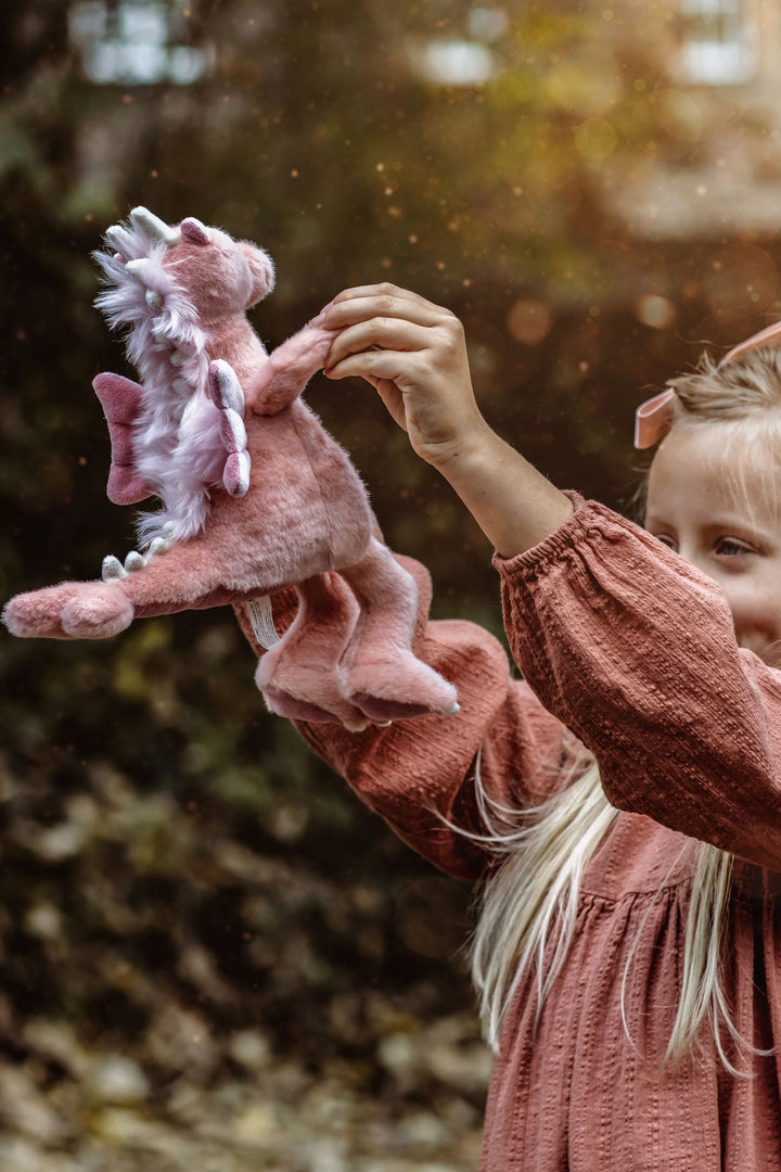 Child holding Hearts the pink dragon plush by Charlie Bears Bearhouse collectible