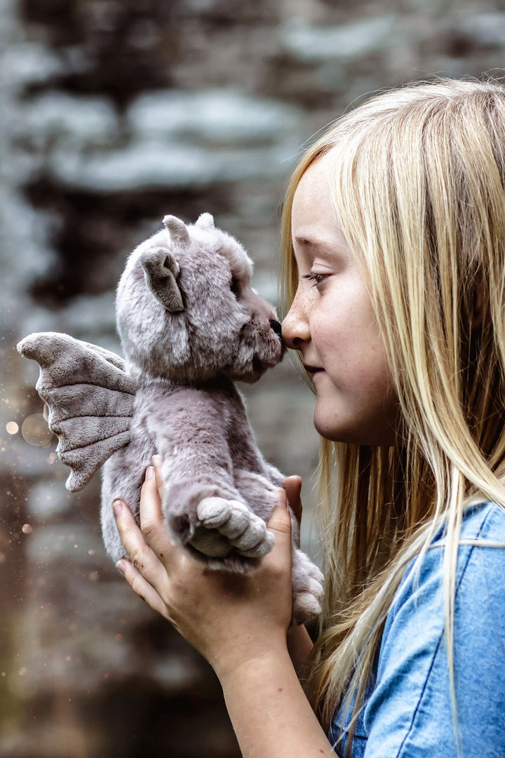 Child holding Moat grey gargoyle plush by Charlie Bears Bearhouse 2025