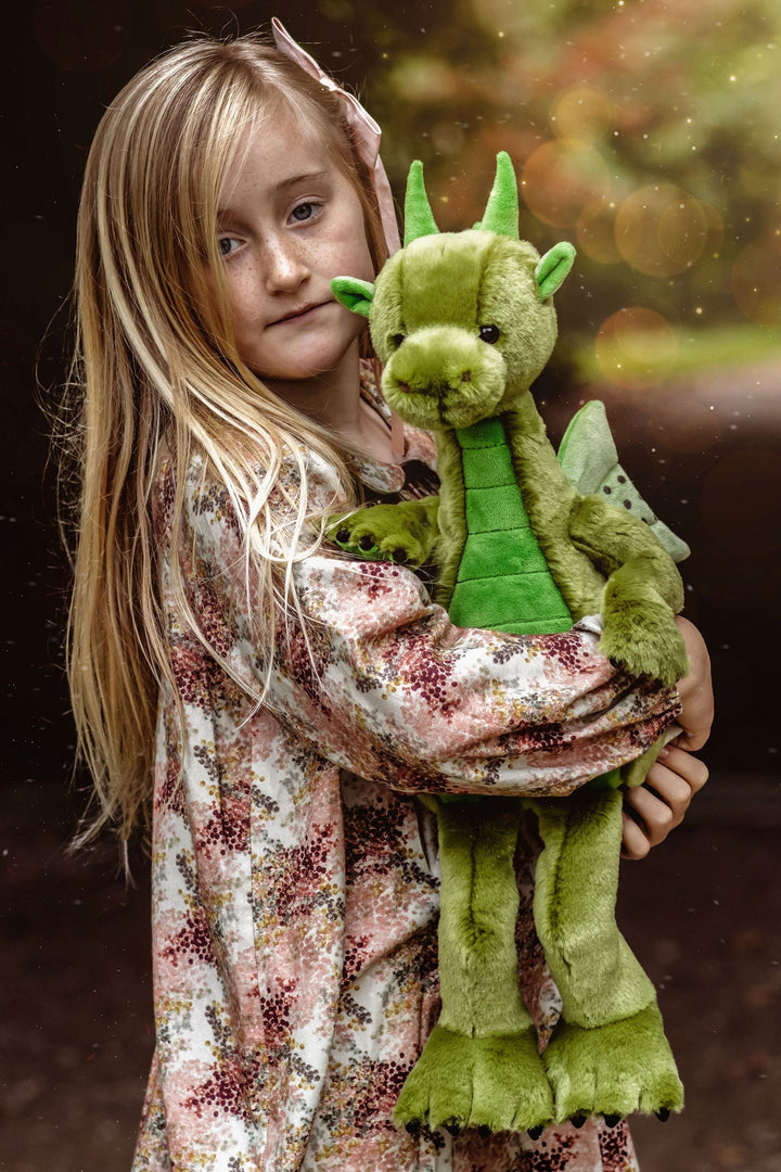 Child holding Deck the Dragon collectible plush by Charlie Bears, a soft green dragon designed as a character-rich keepsake