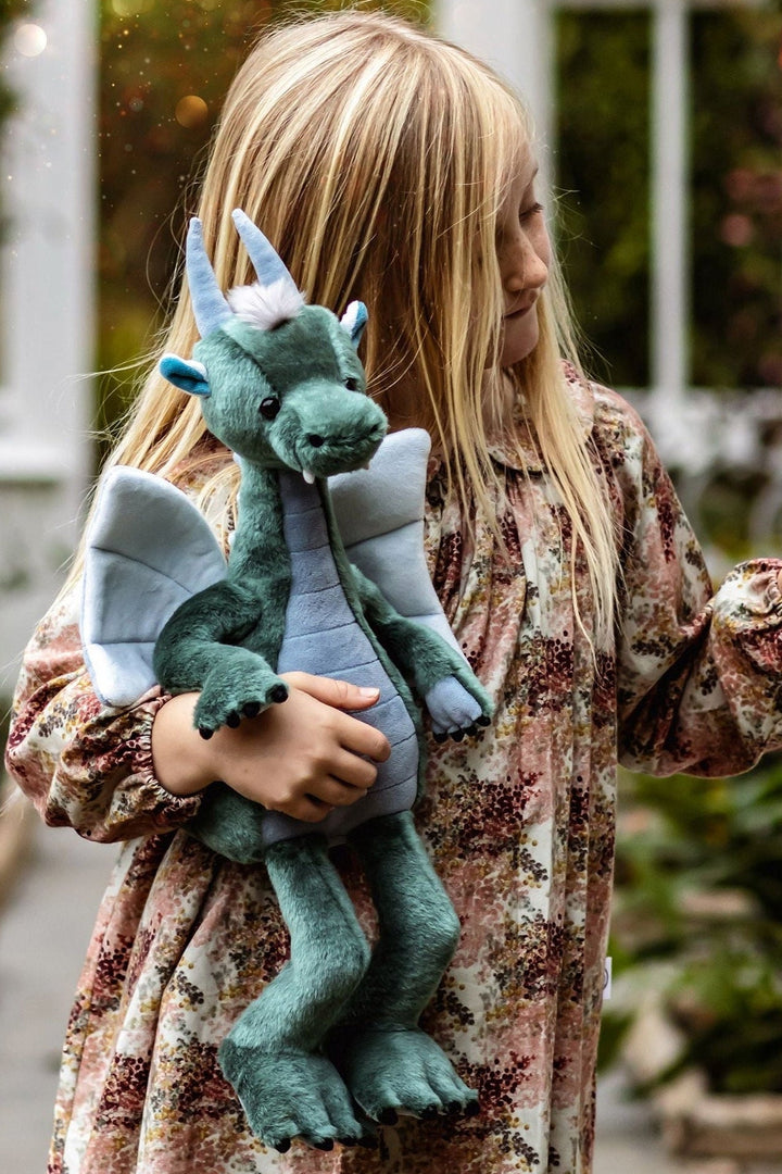 Child holding Spades dragon plush by Charlie Bears Bearhouse, sage green and blue-grey dragon soft toy