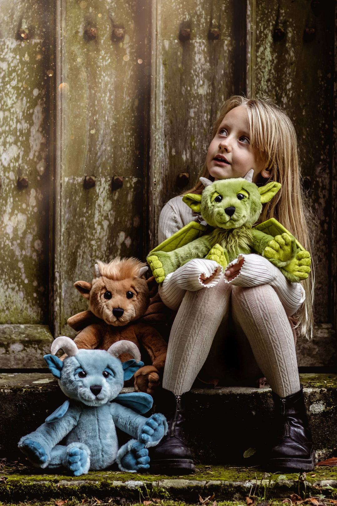 Child holding Spires green gargoyle plush outdoor lifestyle photo