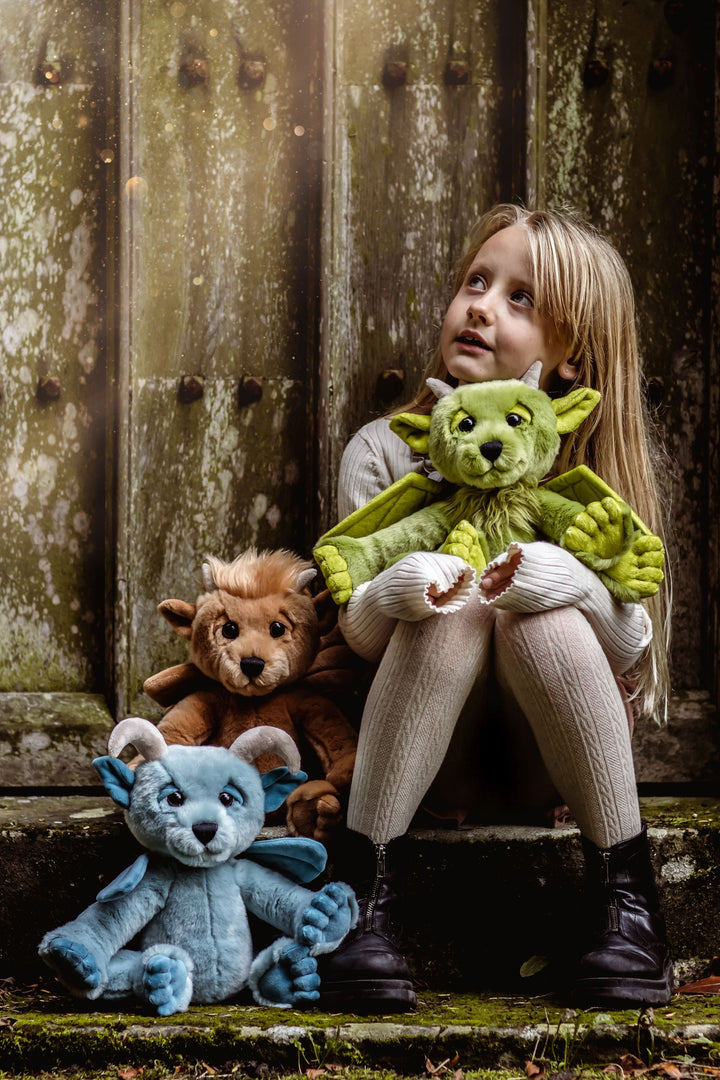 Child holding Spires green gargoyle plush outdoor lifestyle photo