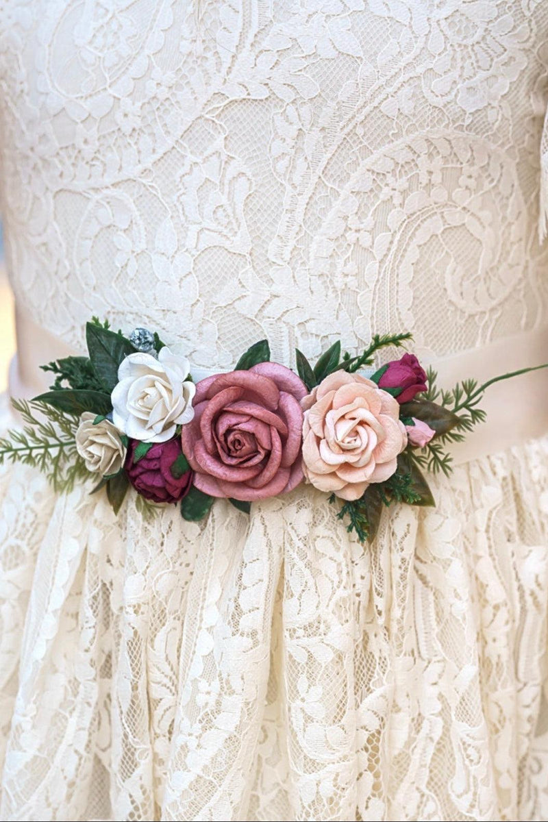 Floral sash on a lace dress with a blurred background