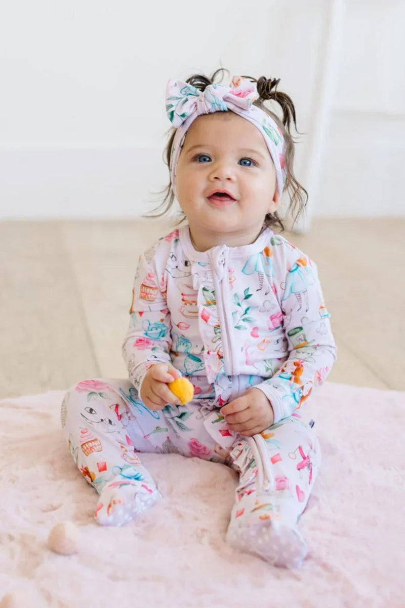 Baby sitting in Adventures with Alice long sleeve bamboo zipper pajamas with convertible feet and dual zipper.