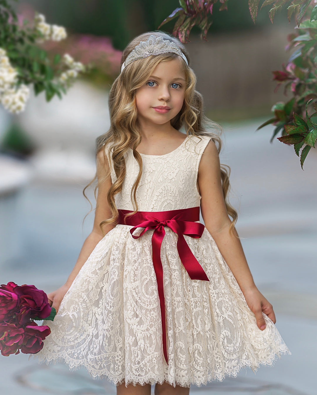 Antique ivory lace flower girl dress close-up showing lace texture and satin sash bow