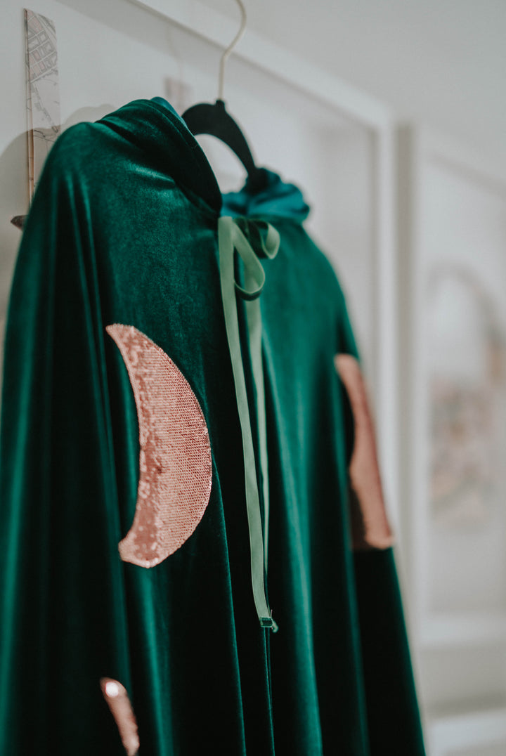 Flat lay side view of green velvet Halloween hocus pocus winifred sanderson cape with ruffle trim.