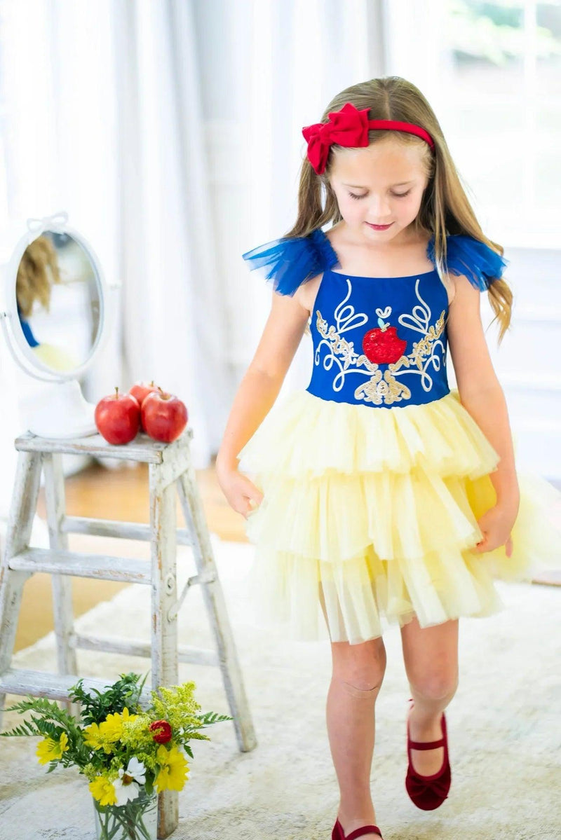 Child smiling in luxury Snow White costume dress with layered yellow tutu