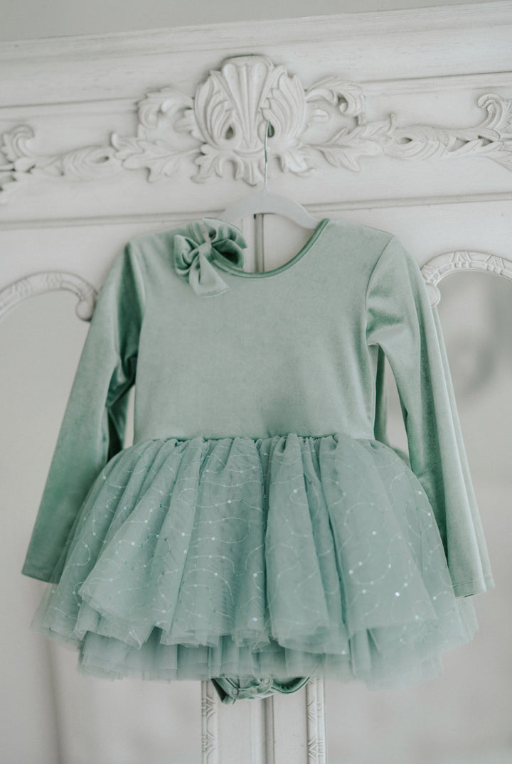 Willow green tutu dress hanging, showing full layered sparkle tulle skirt and soft bodice.