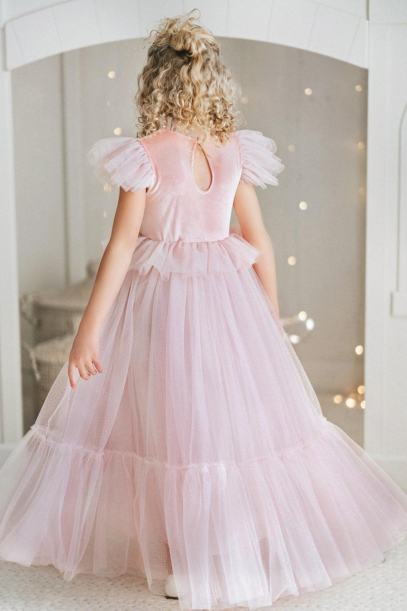 Girl wearing a pink velvet princess dress with sparkling tulle skirt and flutter sleeves for magical dress up and birthday celebrations.