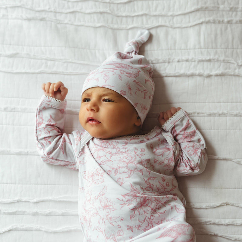 Full view of baby girl in long sleeve bamboo knotted gown in Botanical Lullaby print — featuring gentle stretch, cozy fit, and whimsical woodland toile design.
