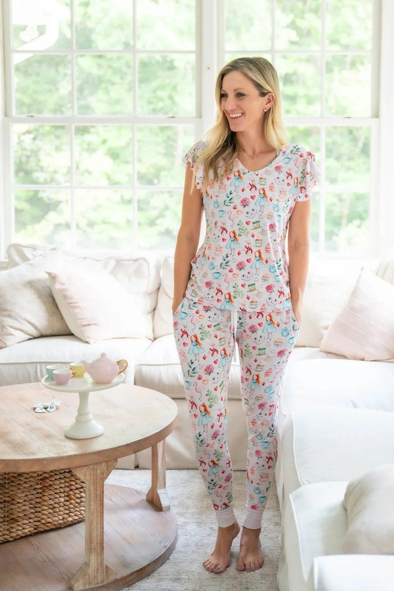 Mom wearing Adventures with Alice bamboo jogger pajamas, featuring short sleeve top and drawstring pants in pink Wonderland print.