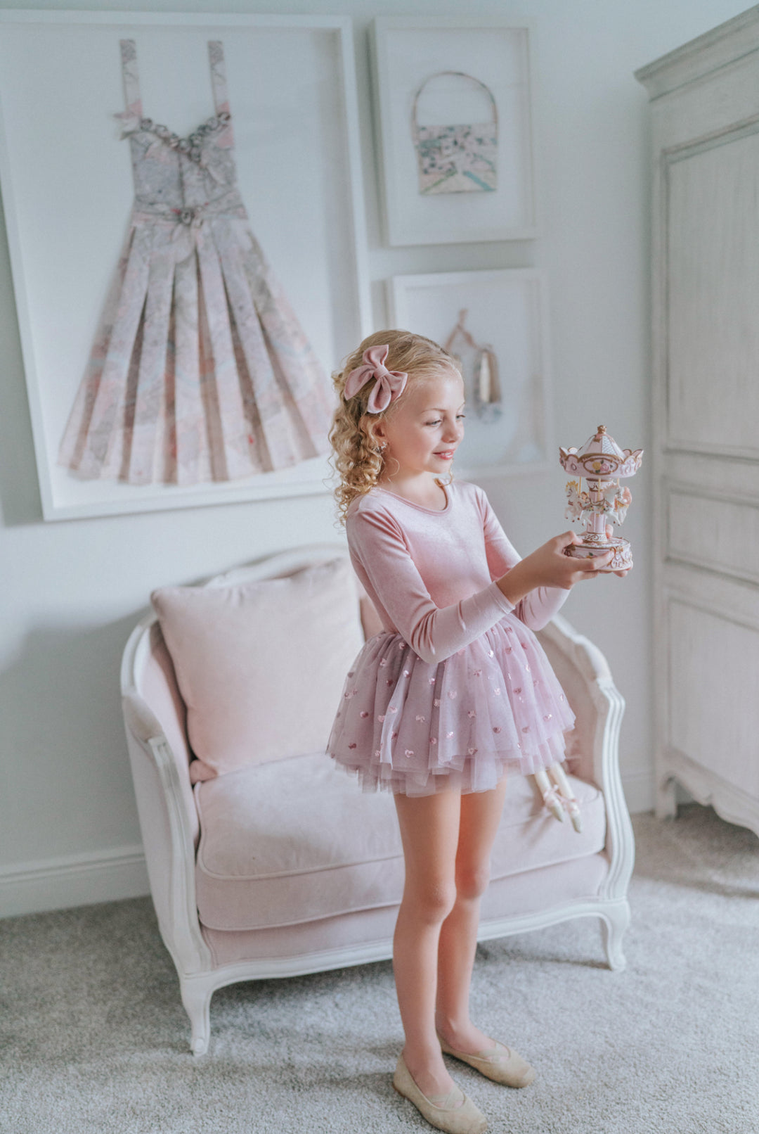 Girl holding a carousel music box while wearing rosewood velvet tutu dress.