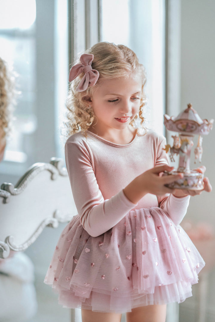 Close-up of heart sequin tulle fabric while held in hand, showing layers and sparkle detail.