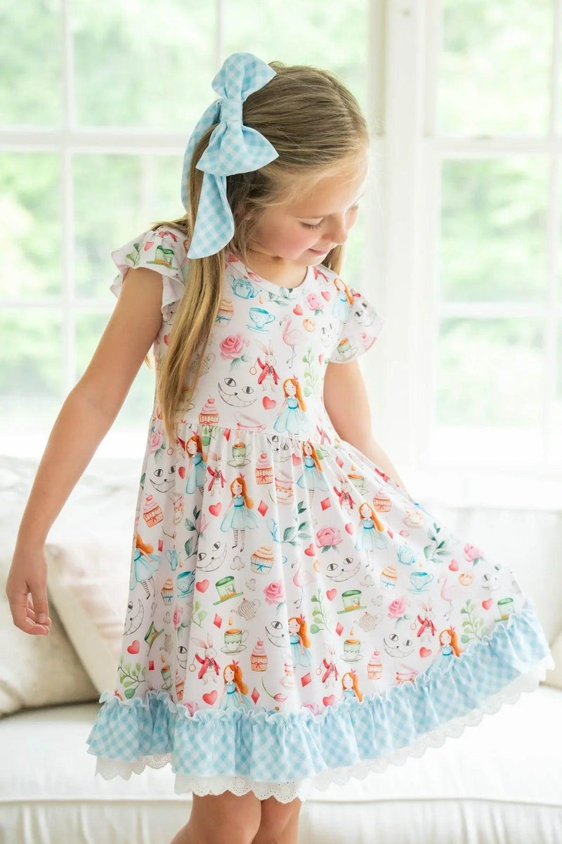 Front view of child wearing Alice in Wonderland-inspired twirl dress with pink print, gingham hem, and lace details.
