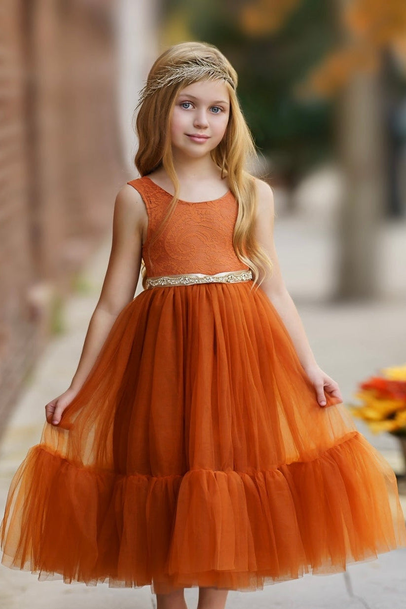 Terracotta burnt orange flower girl dress styled for woodland ceremony