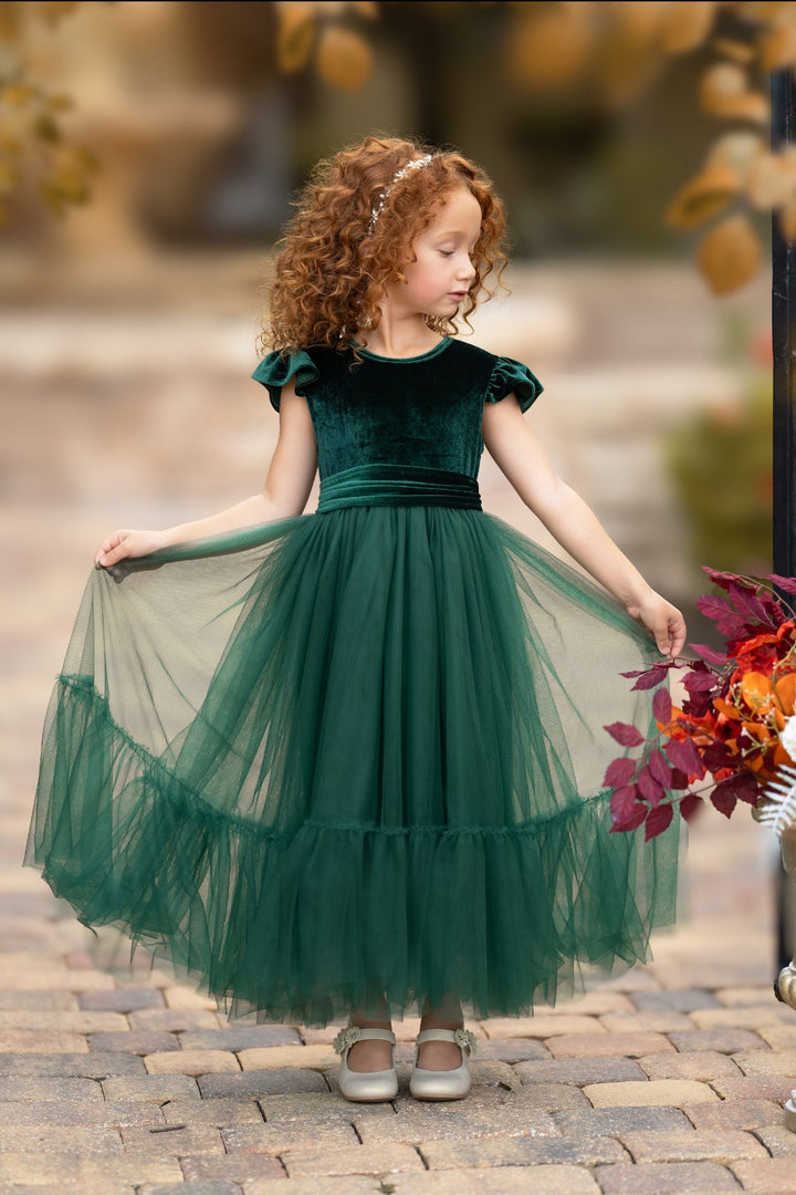 Forest green velvet flower girl dress with ruffle sleeves and plain tulle skirt, walking outdoors