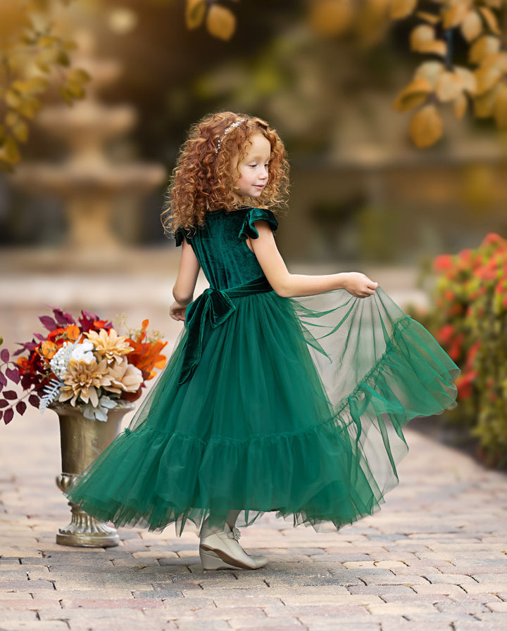 Forest green velvet flower girl dress showing movement of layered tulle skirt while twirling