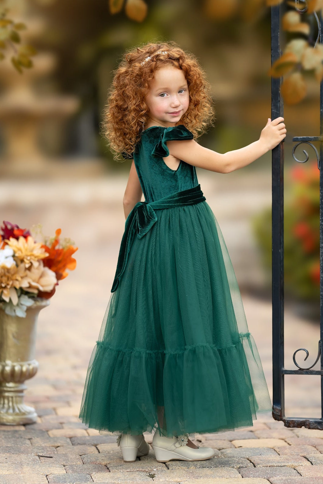 Side view of forest green velvet flower girl dress with closed back and full skirt