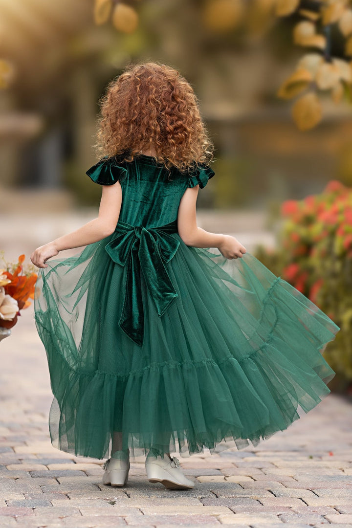 Back view of forest green velvet flower girl dress with sash tie and flowing tulle skirt