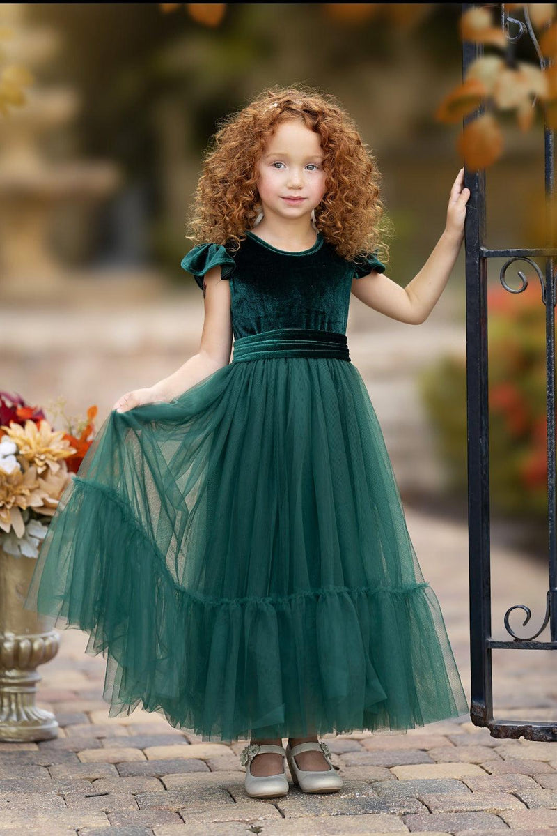 Forest green velvet flower girl dress with ruffle sleeves and full tulle skirt, front view outdoors
