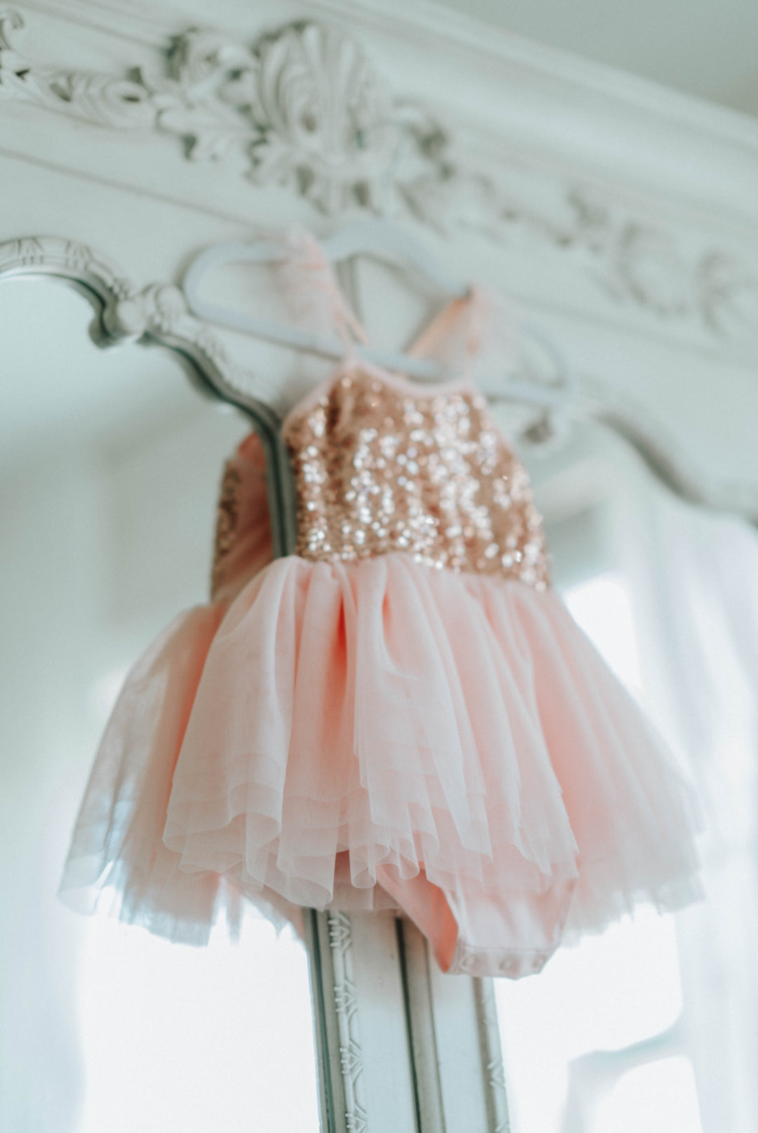 Back design of pink sequin tutu dress showing straps and layered tulle skirt.
