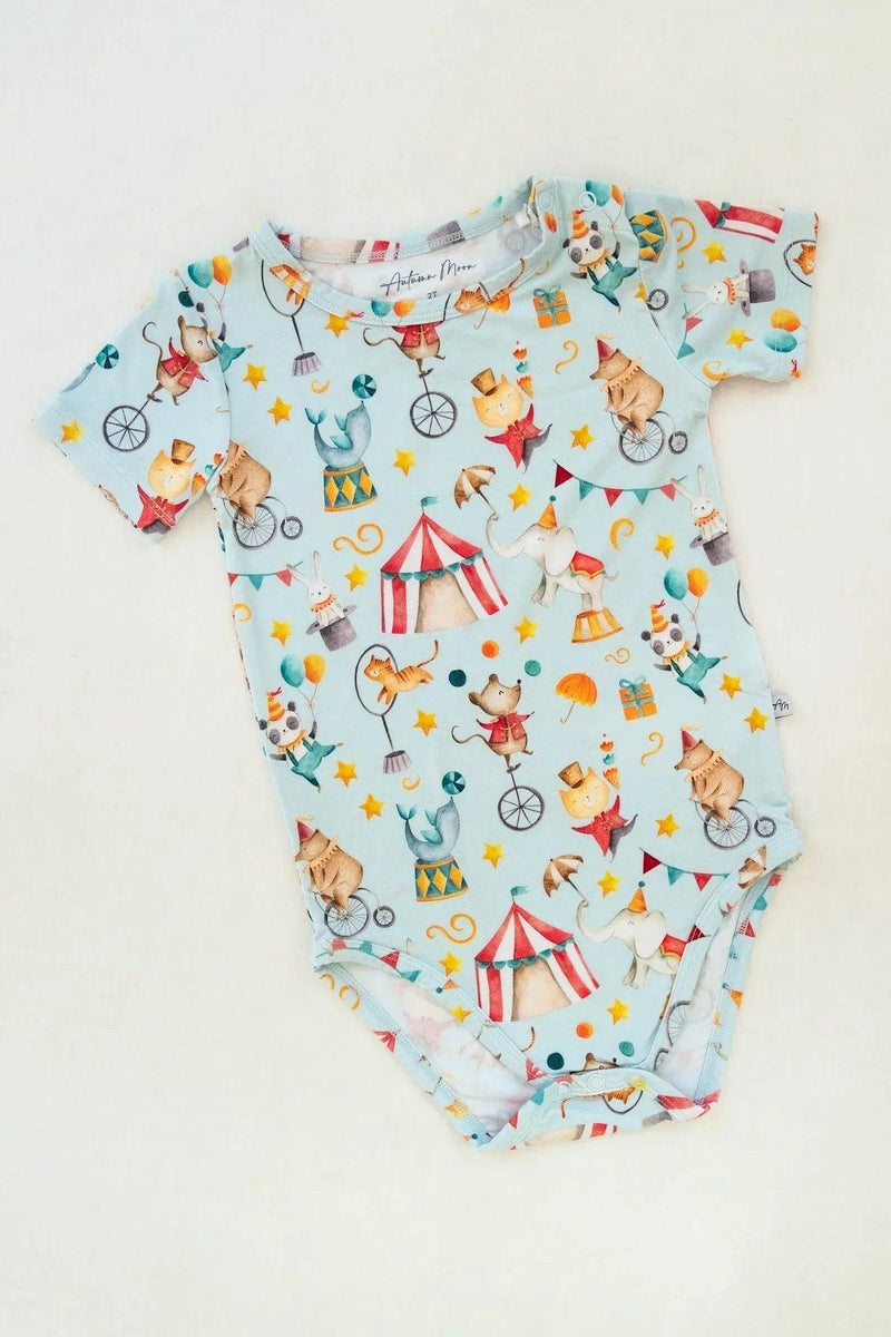 Flat lay of Take Me to the Circus bamboo baby bodysuit with short sleeves and snap bottom closure.