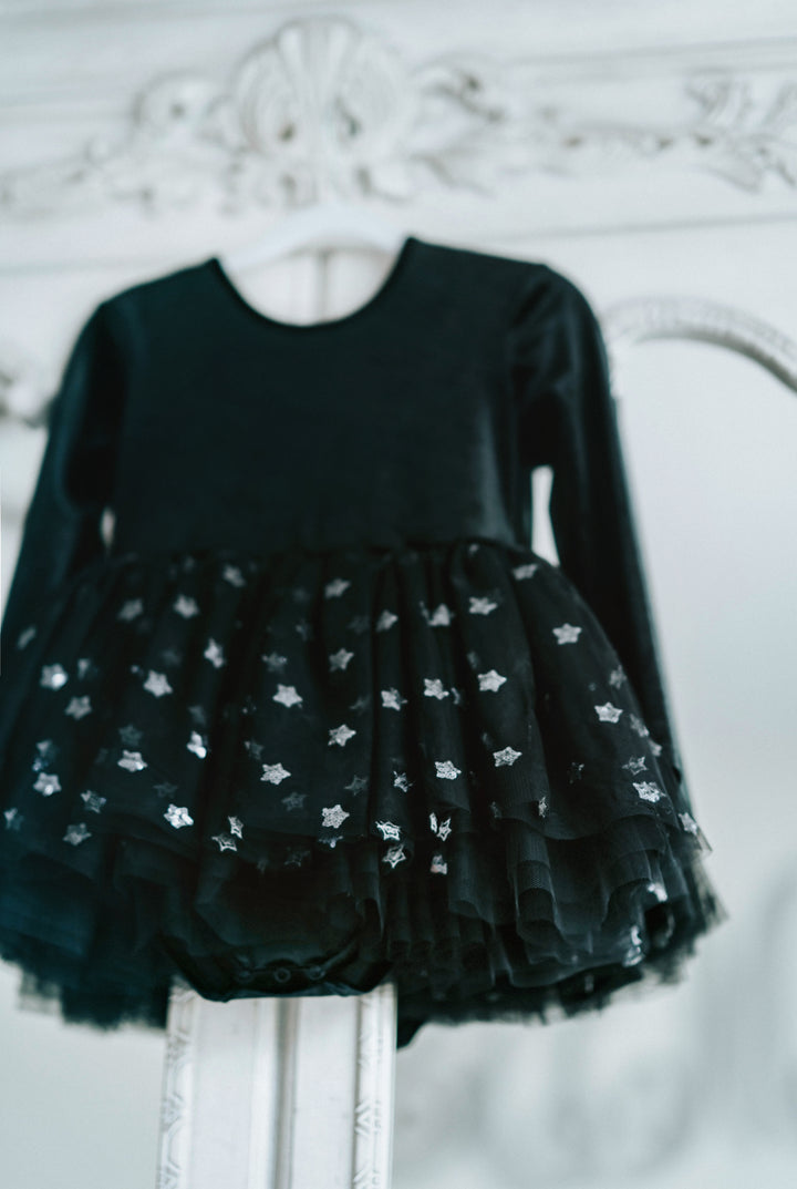 Close-up of star tulle skirt detail on black velvet twirl dress.
