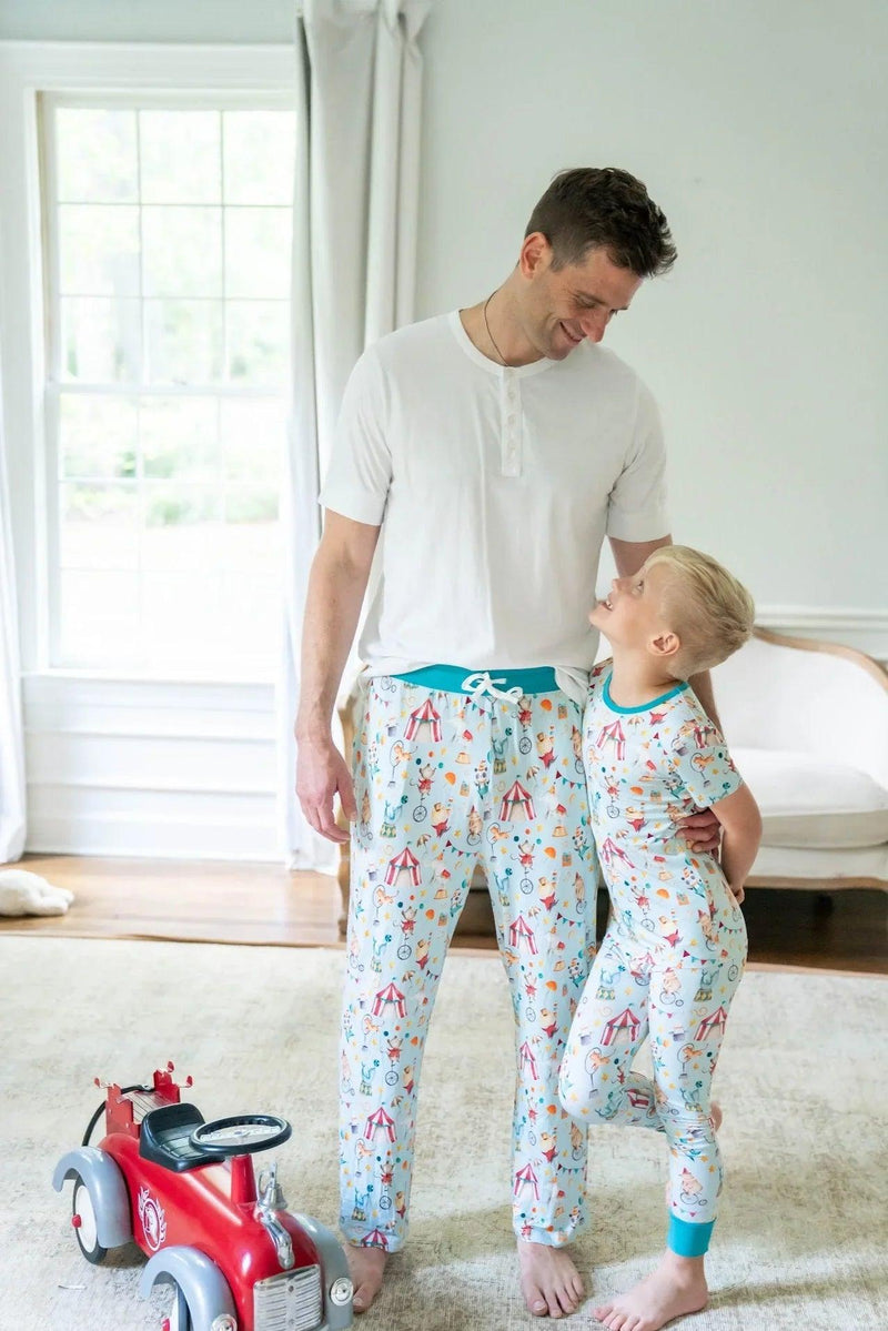Dad and son wearing matching Take Me to the Circus bamboo family matching pajamas, featuring adult sleep pants and kids two-piece set.