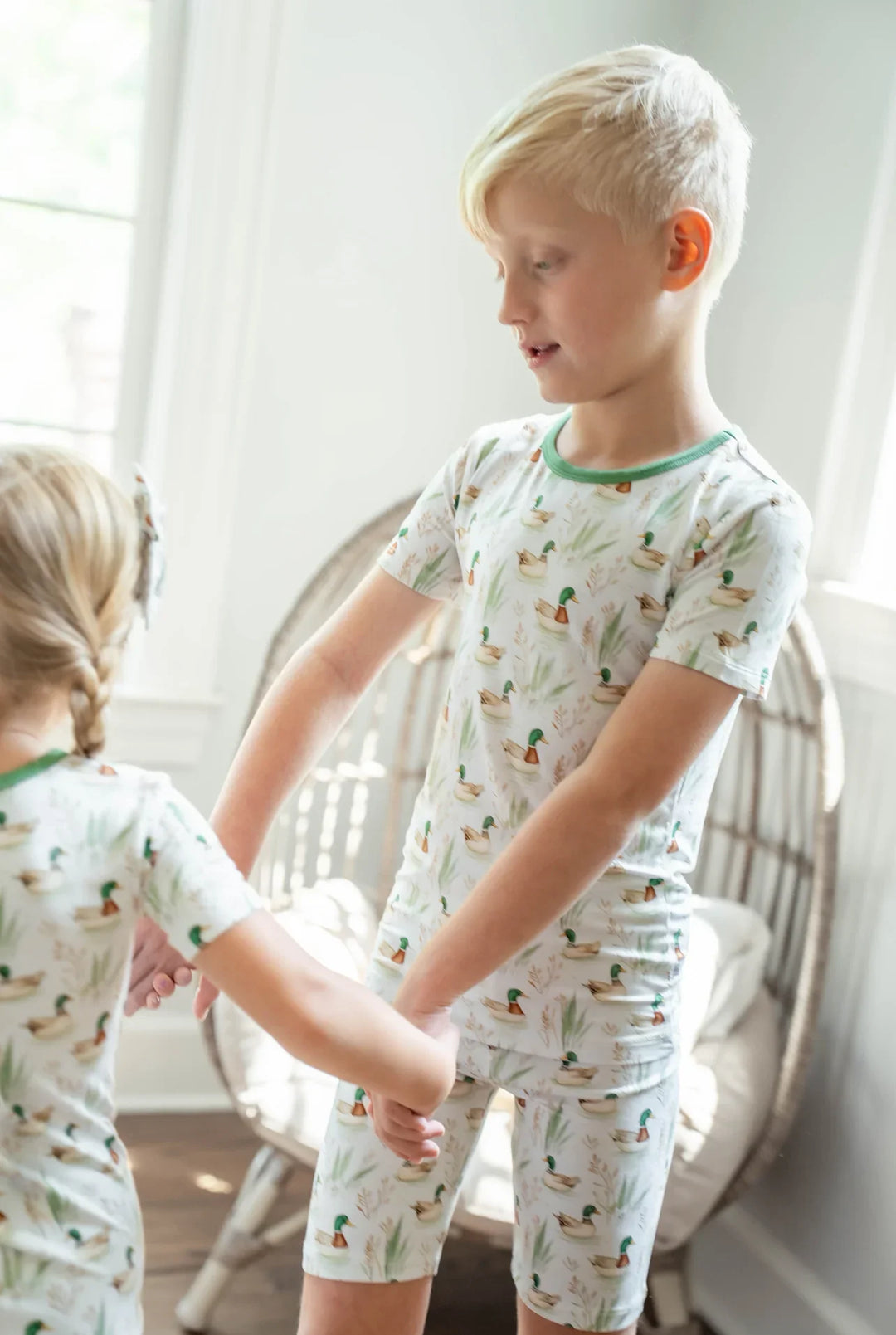 Toddler boy lounging in mallard duck bamboo pajamas, breathable two-piece sleepwear for summer.